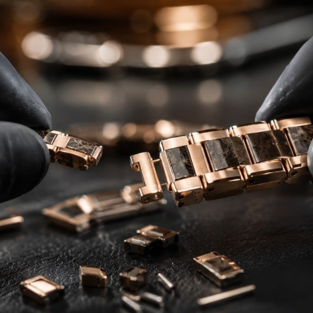 Craftsperson assembling a metal watch bracelet link by link